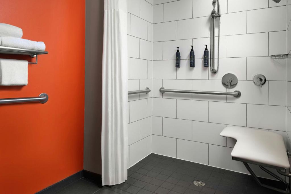 a bathroom with a shower with an orange door at Aloft Austin Downtown in Austin
