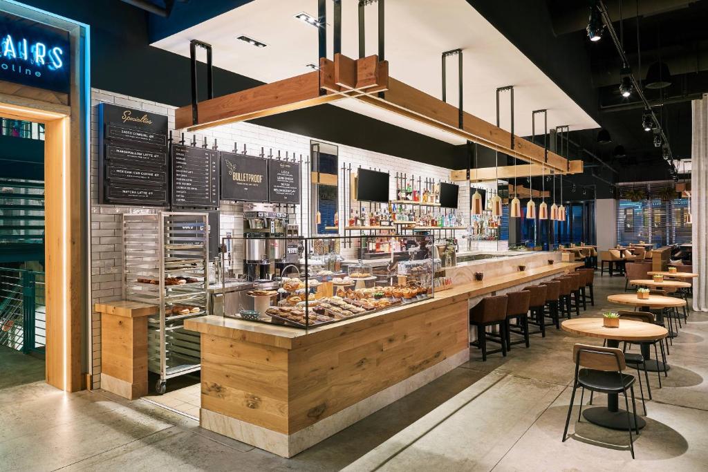 a restaurant with a counter with tables and chairs at Aloft Austin Downtown in Austin