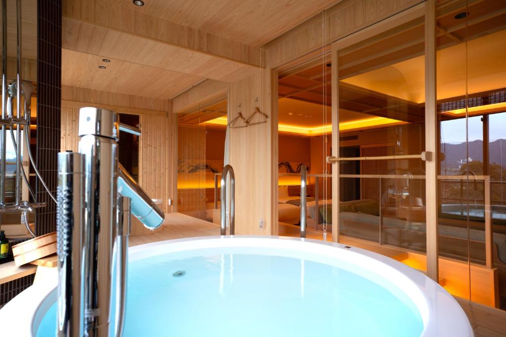 a bathroom with a large tub in a room at Miyajima Grand Hotel Arimoto in Miyajima