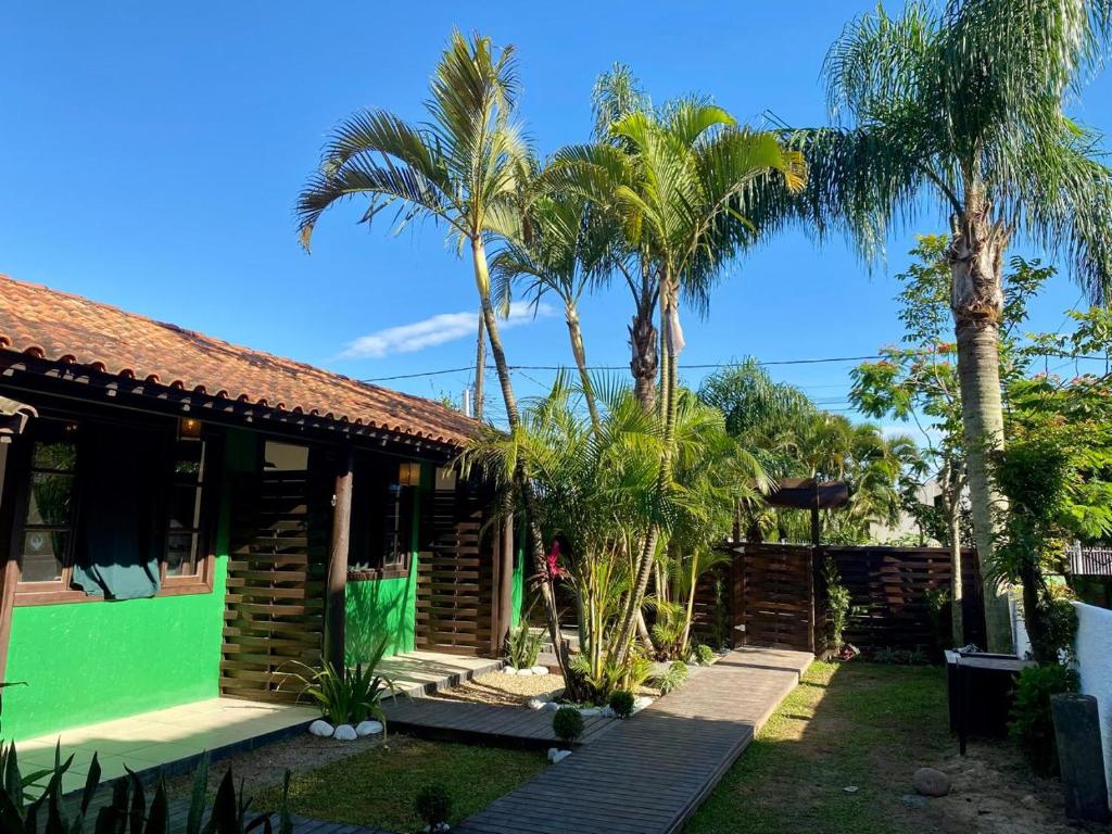 una casa con delle palme davanti di Hospedaria aconchego 5 a Garopaba