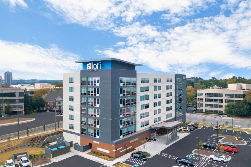 サンディスプリングスにあるAloft Atlanta Perimeter Centerの駐車場付きのアパートメントビルの空中ビュー