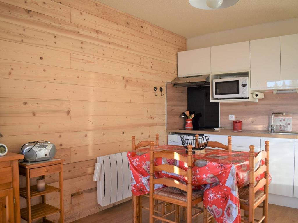- une cuisine avec des murs en bois et une table avec des chaises dans l'établissement Confortable 2 Pièces à Bolquère, Proche Commerce et Ski - FR-1-592-81, à Font-Romeu-Odeillo-Via