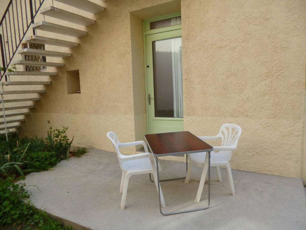 2 chaises blanches et une table devant un bâtiment dans l'établissement T2 Confortable - Près Centre-Ville avec Parking - FR-1-571-71, à Balaruc-les-Bains