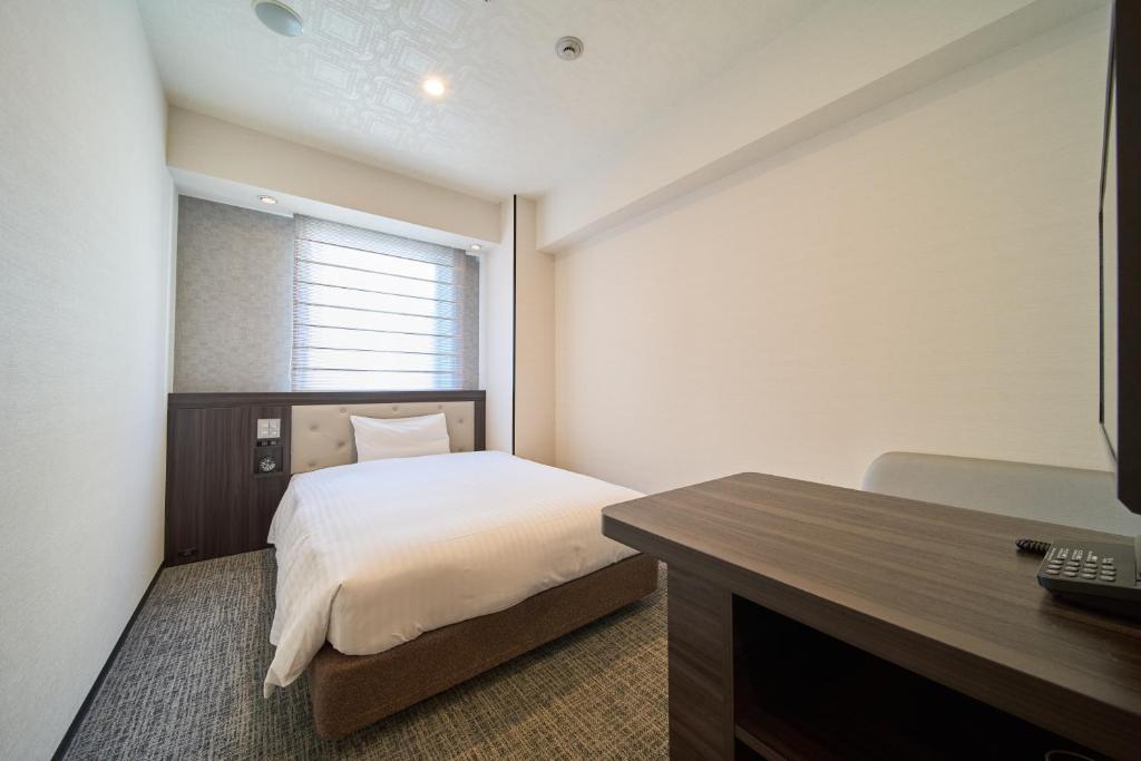 Postel nebo postele na pokoji v ubytování Via Inn Umeda