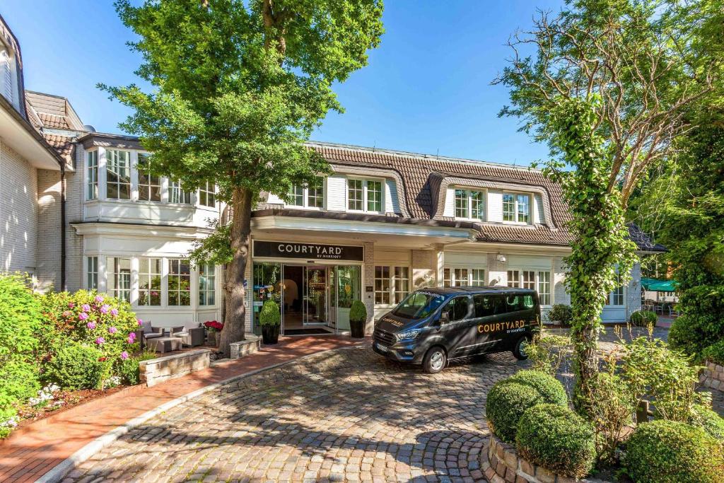 a jeep parked in front of a house at Courtyard by Marriott Hamburg Airport in Hamburg