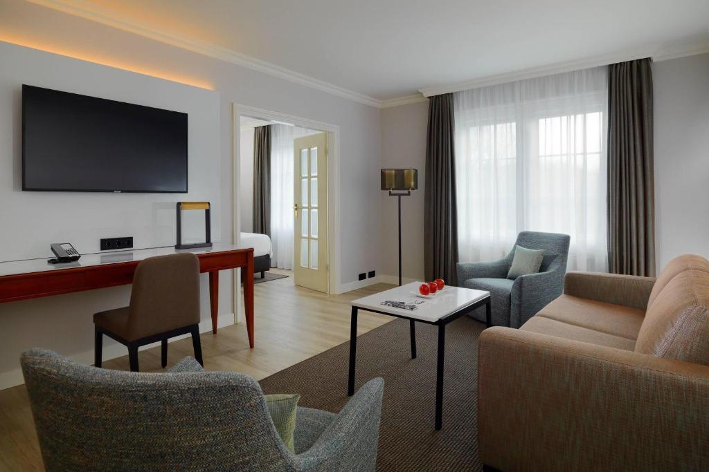a living room with a couch and a table at Courtyard by Marriott Hamburg Airport in Hamburg
