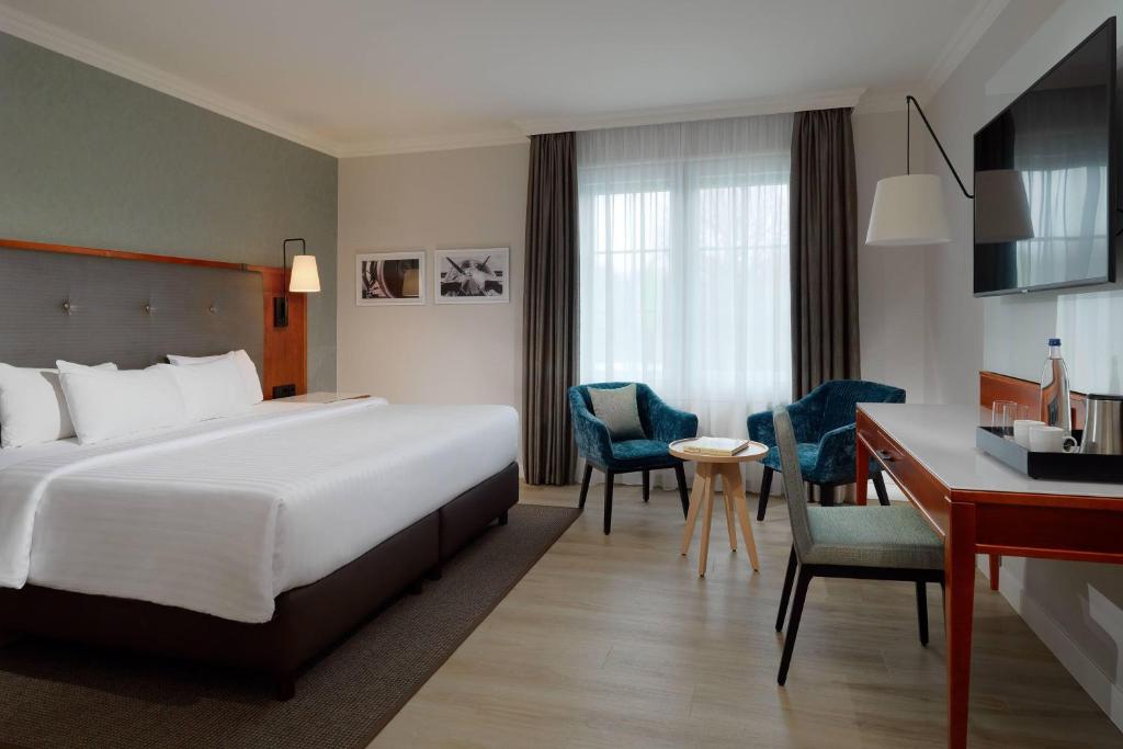 a hotel room with a bed and a desk at Courtyard by Marriott Hamburg Airport in Hamburg