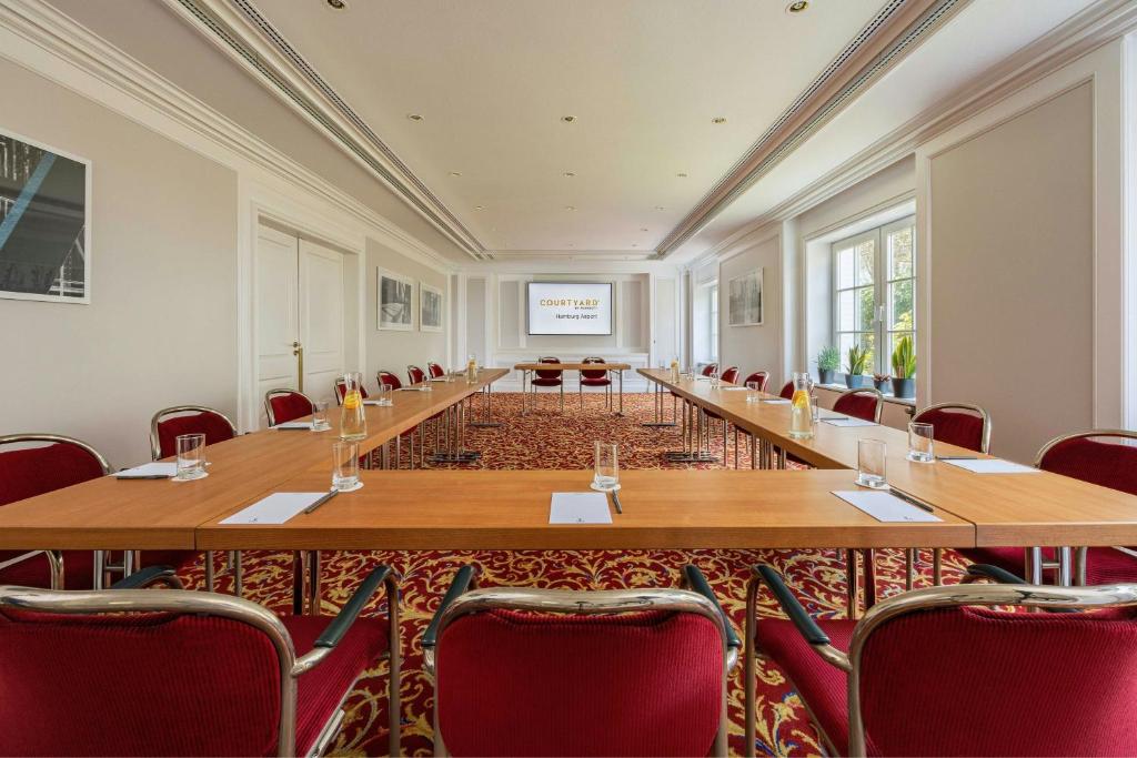 a large conference room with a long table and chairs at Courtyard by Marriott Hamburg Airport in Hamburg