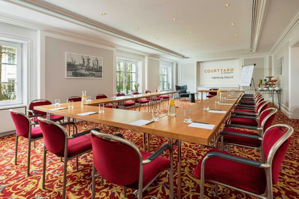 a large conference room with a long table and chairs at Courtyard by Marriott Hamburg Airport in Hamburg