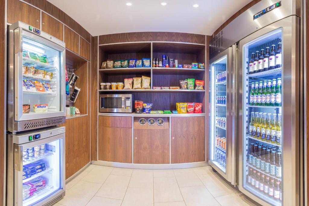 a kitchen with wooden walls and a large refrigerator at Courtyard by Marriott Glasgow Airport in Paisley