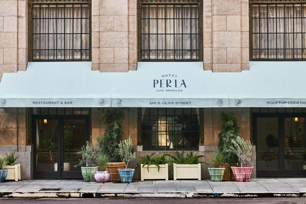 a facade of a building with potted plants on the sidewalk at Hotel Per La, Autograph Collection in Los Angeles