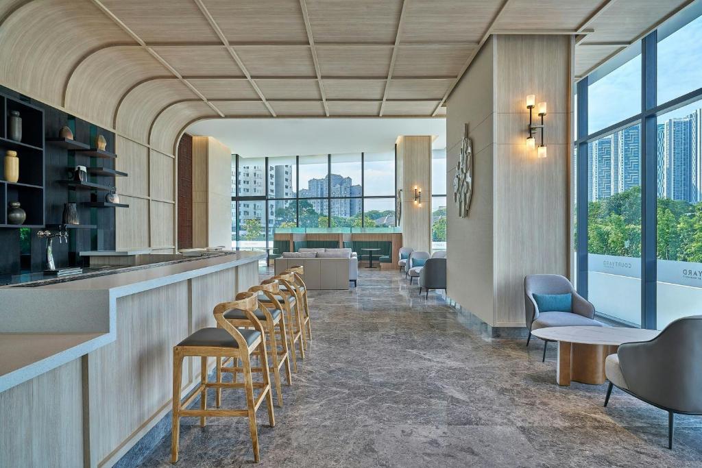 A lobby bar and lounge seating occupy a bright, window-lined space with high-rise views.