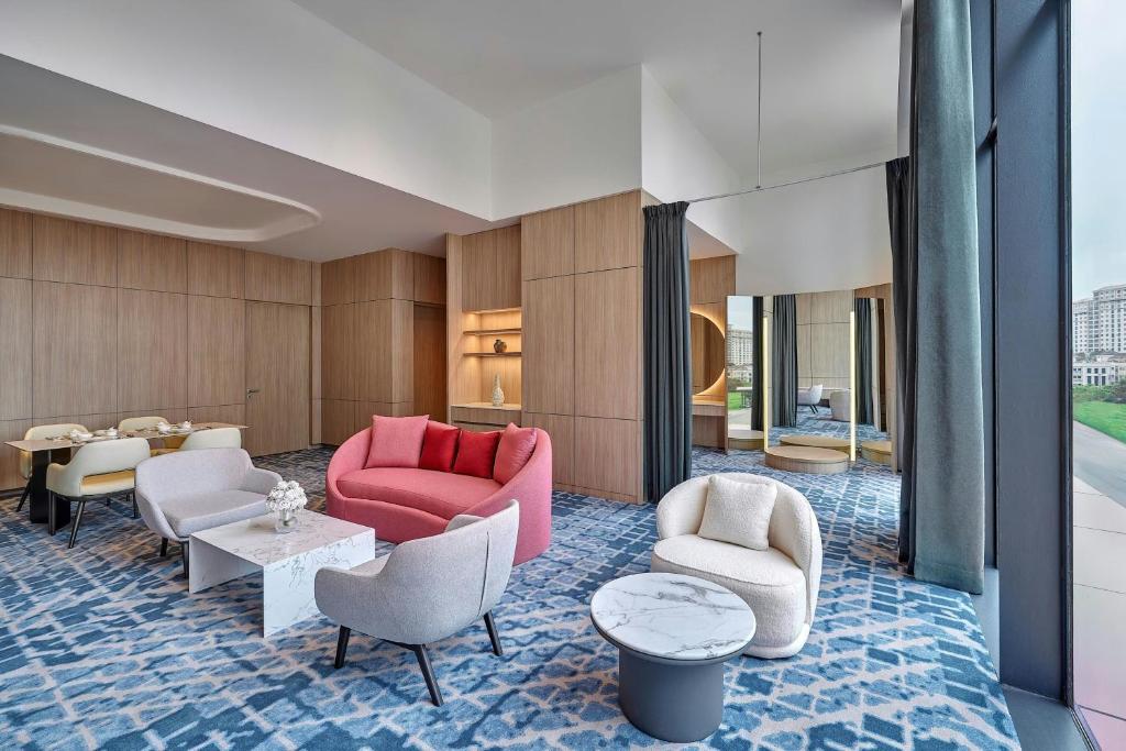 A bright, designer-furnished lobby lounge with floor-to-ceiling windows and city views.
