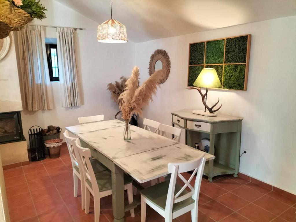 a dining room with a table and chairs at Cortijo Rural El Contador, con chimenea in Constantina