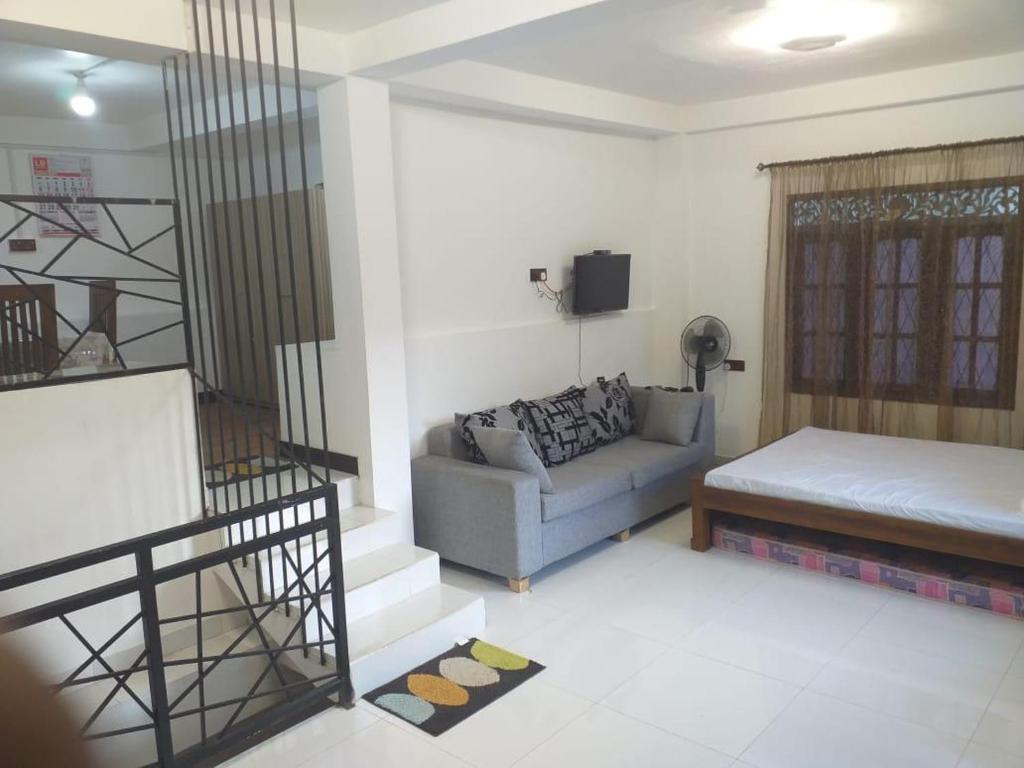 a living room with a couch and a bed at Villa White Orchid in Hatton