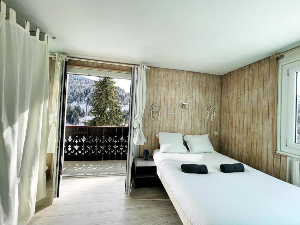 une chambre avec deux lits et une grande fenêtre dans l'établissement La Vouagère - mountain view, aux Gets