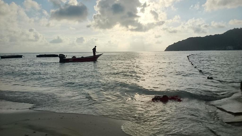 a man standing on a boat in the water at Suhaila Palace in Perhentian Islands