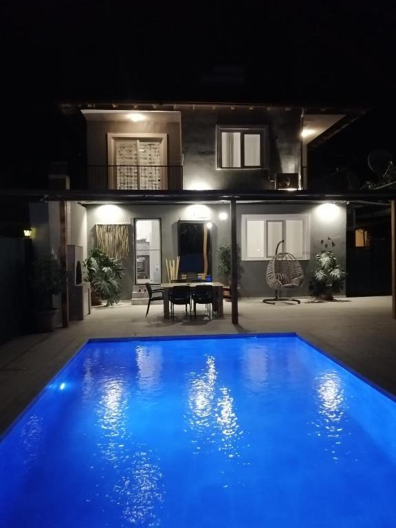 a blue pool in front of a house at night at Villa angel in Sarigerme