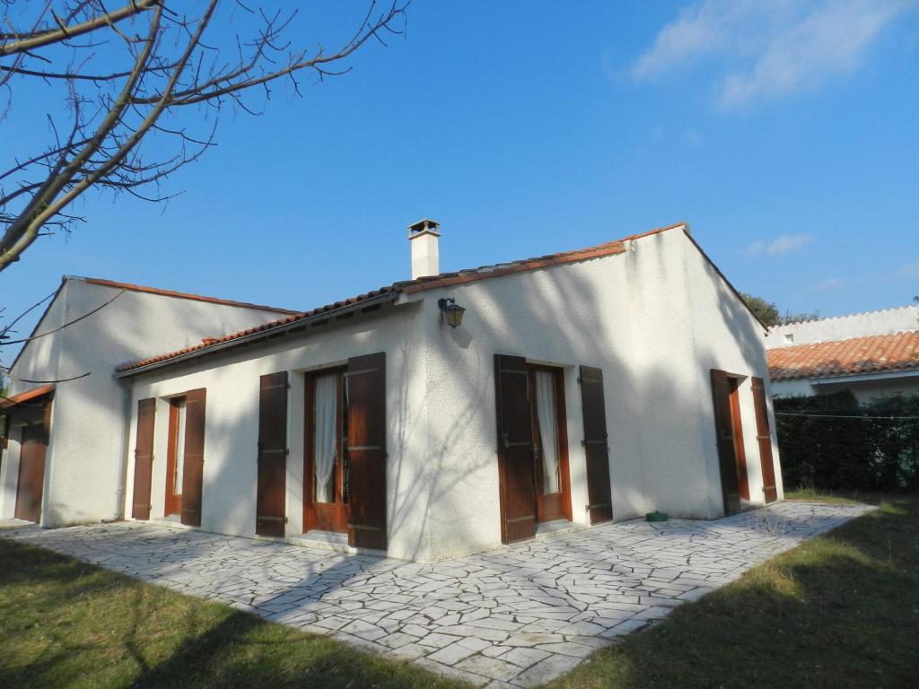 une maison blanche avec une allée en briques devant dans l'établissement Maison à 8min de plage Giraudière, à Grand-Village-Plage