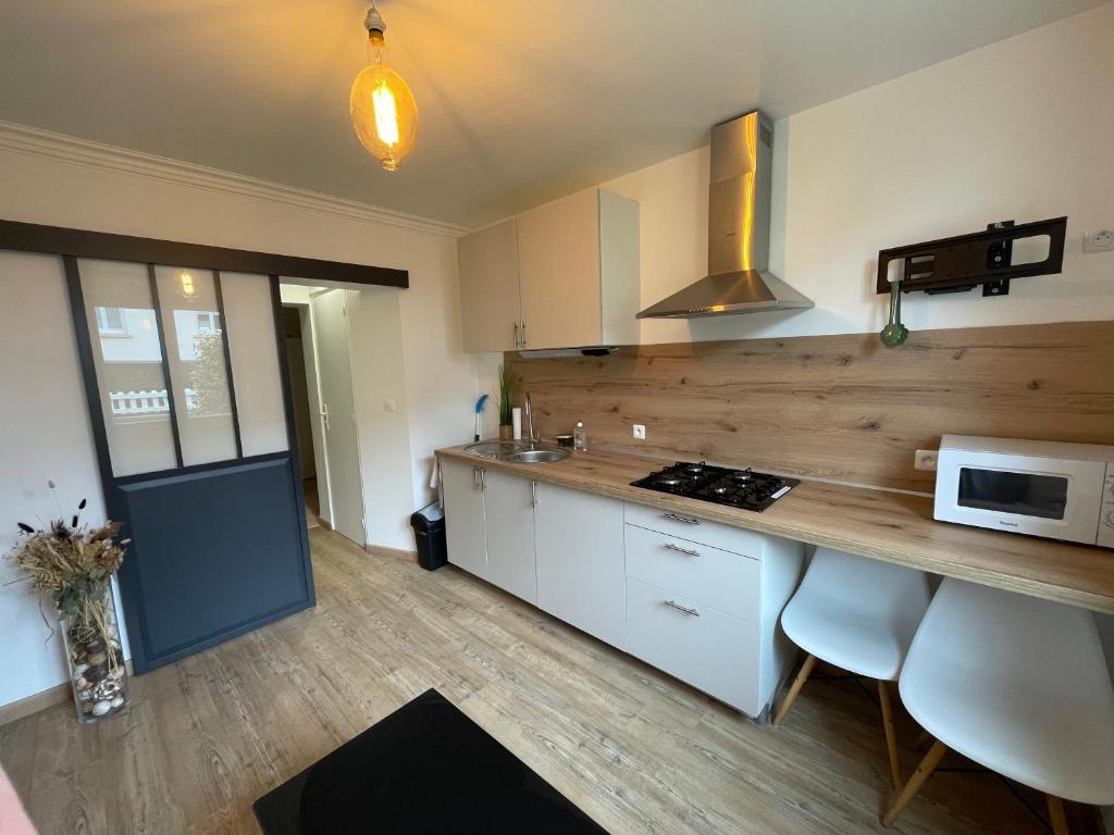 a kitchen with white cabinets and a counter top at L'escapade, proche centre ville in Quimper