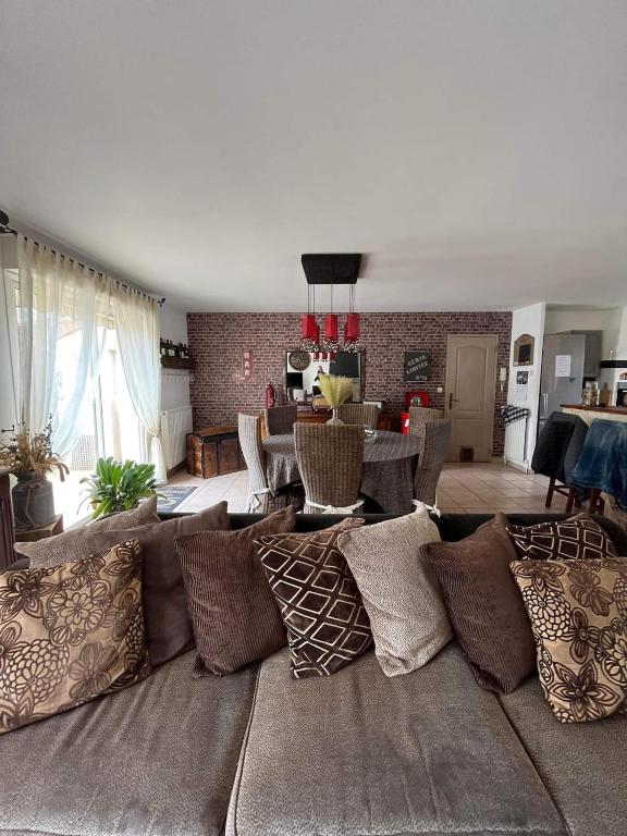 - un salon avec un canapé et de nombreux oreillers dans l'établissement Maison proche du Circuit des 24h, à Ruaudin