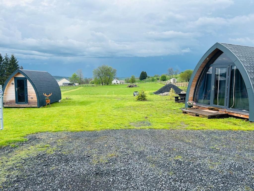 a building with a grassy yard with a house at Chalet cosy en Aubrac in Nasbinals