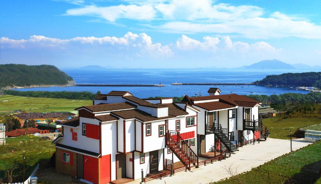 een huis op een heuvel met uitzicht op het water bij Bluesean Pension in Namhae