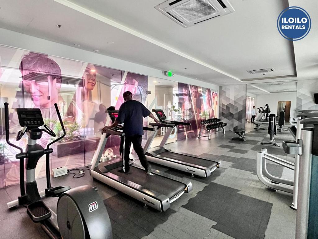a man on a treadmill in a gym at Room in Condo - Cozy, Modern and Homey, The Bliss Studio in Iloilo City