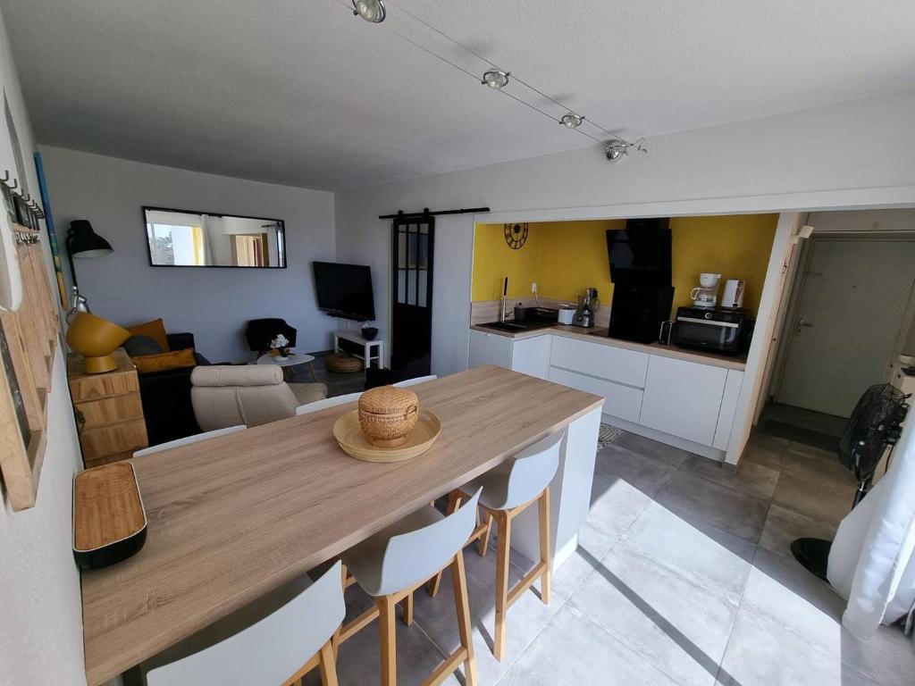 une cuisine et une salle à manger avec une table et des chaises dans l'établissement Superbe appartement entièrement rénové 4EST211, au Barcarès