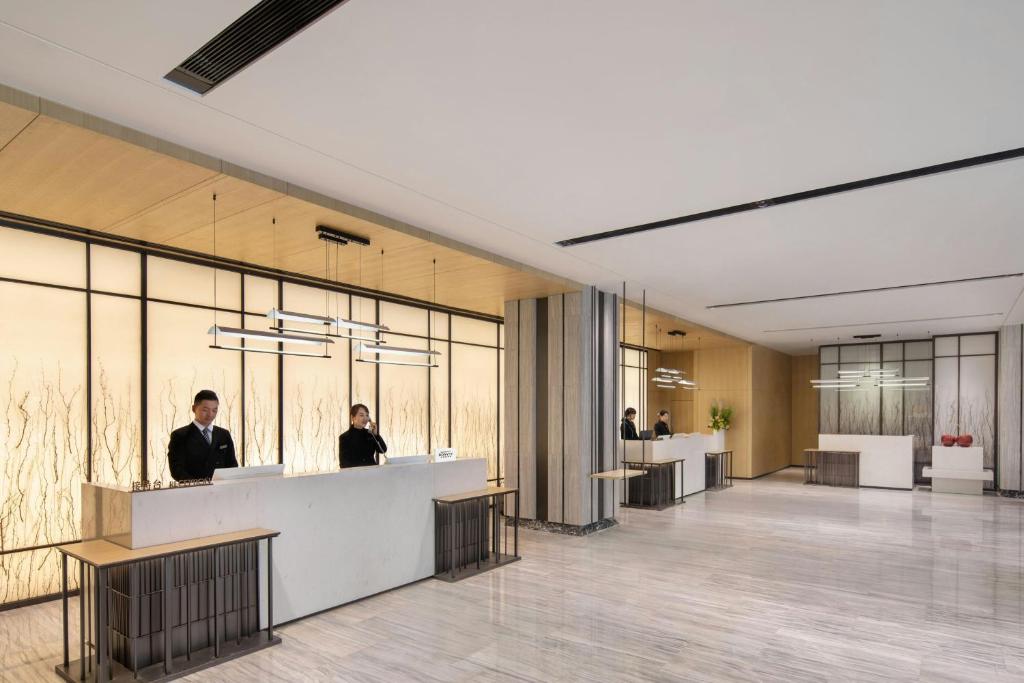 a rendering of a lobby with people at desks at Courtyard by Marriott Nanchang in Nanchang