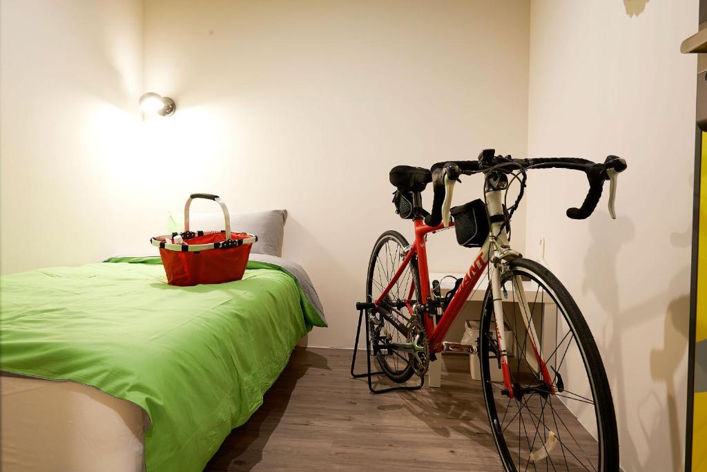 a bike parked next to a bed in a room at Ease Single Inn in Taichung