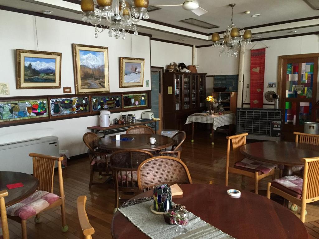 a dining room with wooden tables and chairs at Tsugaike Ski House in Otari