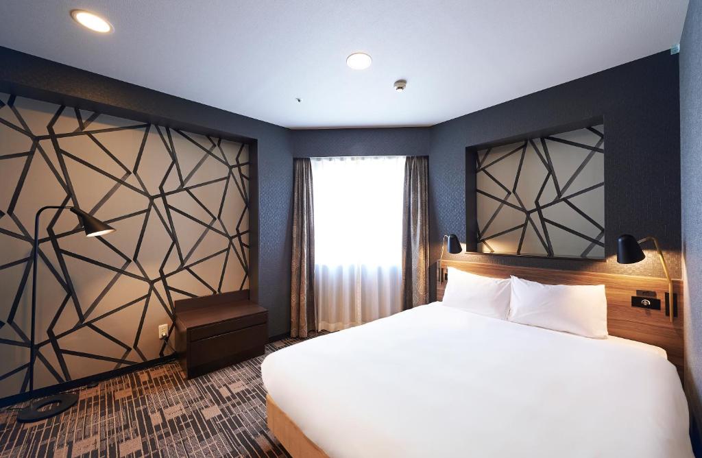 Postel nebo postele na pokoji v ubytování Sotetsu Fresa Inn Kawasaki-Higashiguchi