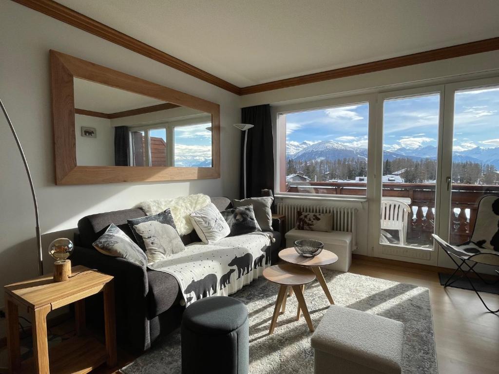 a living room with a couch and a large window at Cosy Rooftop Downtown Crans-Montana with Stunning View and Swimming Pool in Crans-Montana