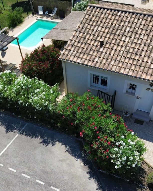 - une vue sur une maison fleurie et une piscine dans l'établissement La maison de Goudargues, à Goudargues