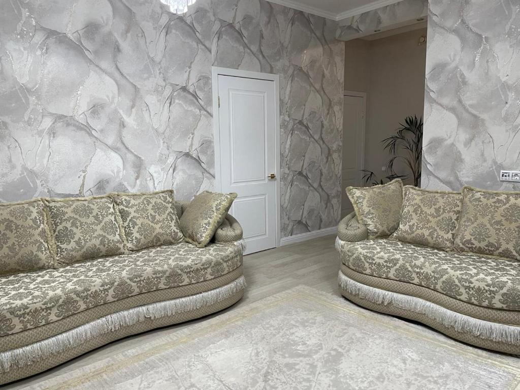 a living room with two couches and a stone wall at Apartment 33 in Astana