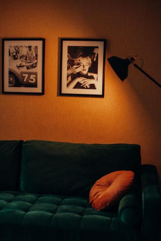 a living room with a green couch and pictures on the wall at Anna Louise in Sondershausen