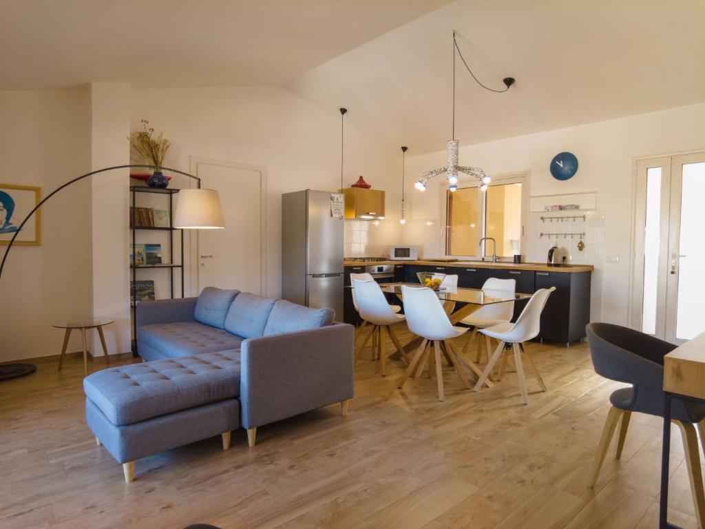 un salon avec un canapé bleu et une cuisine dans l'établissement Attic With a View, à Fluminimaggiore