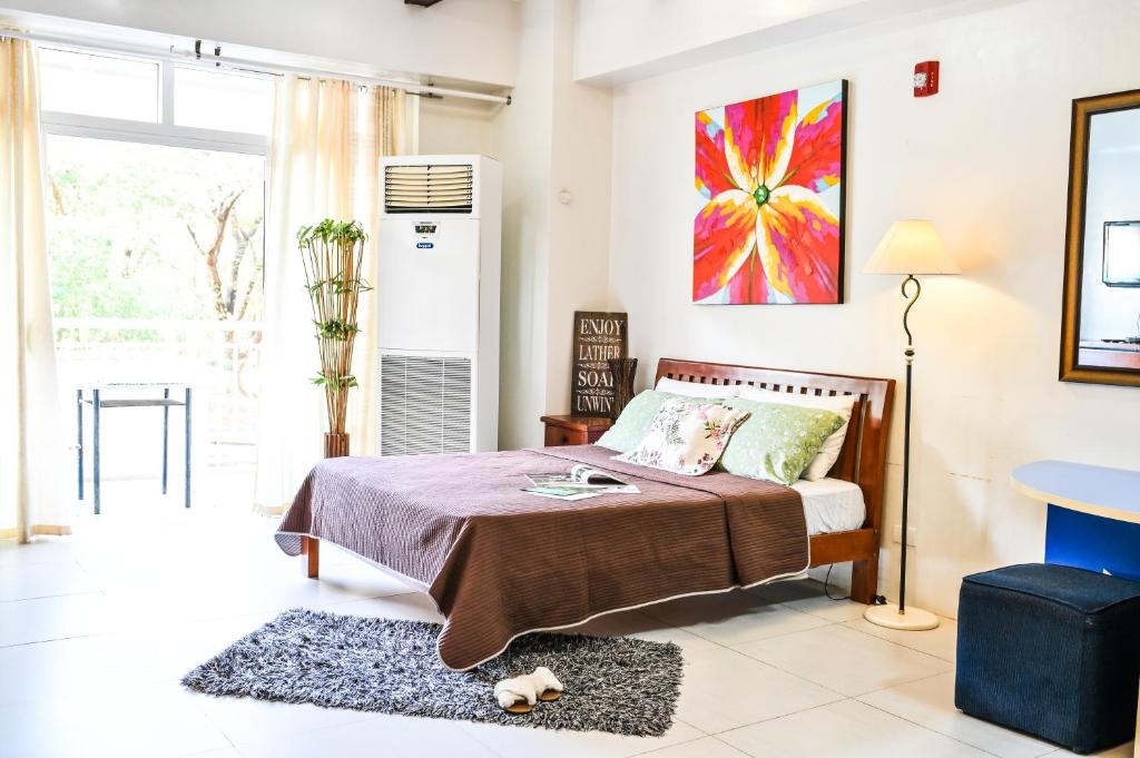 una camera da letto con un letto e una grande finestra di Jacana A 1BR Pico de Loro by PTours a Nasugbu