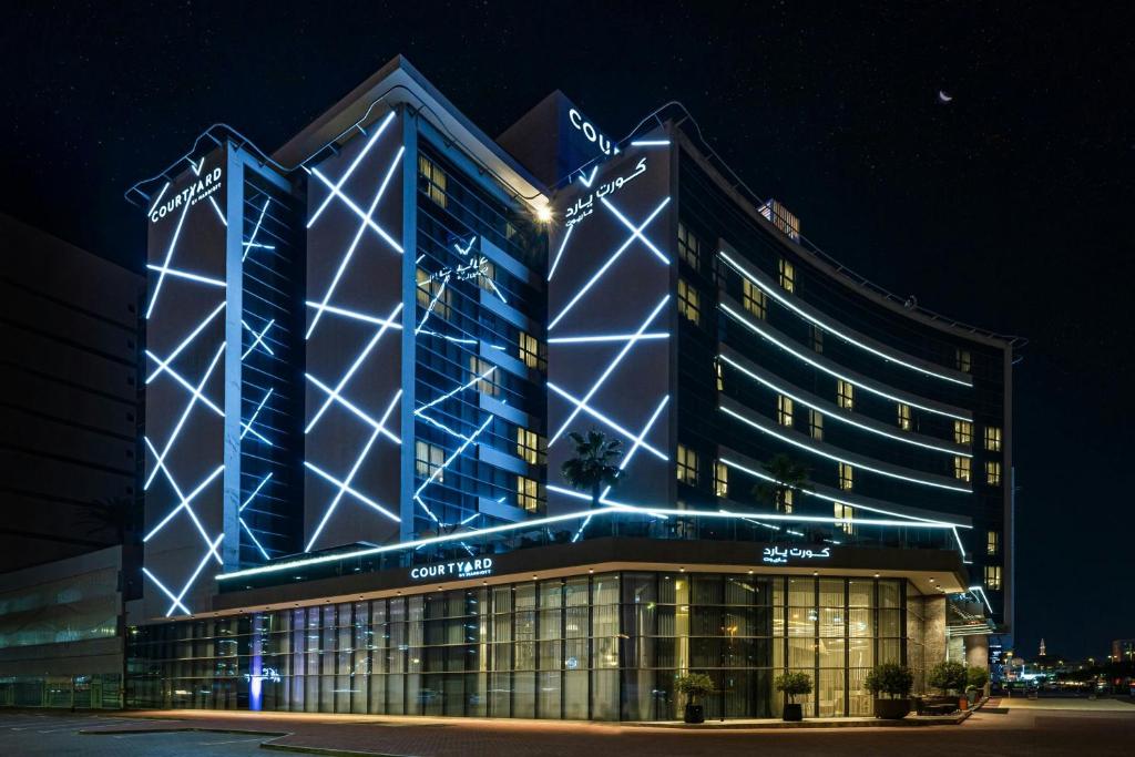 a large building with lights on it at night at Courtyard by Marriott World Trade Centre, Dubai in Dubai