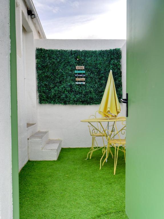 d'une terrasse avec une table et un parasol jaune. dans l'établissement Studio avec jardinet, à Martigues