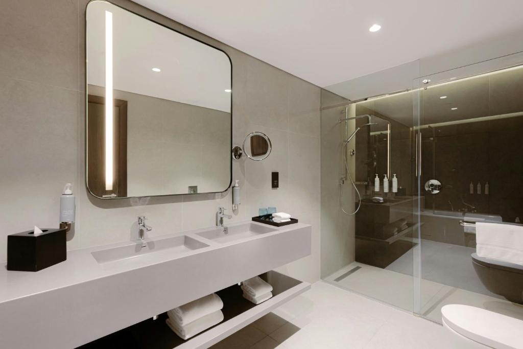 a bathroom with two sinks and a mirror and a shower at Courtyard by Marriott World Trade Centre, Dubai in Dubai