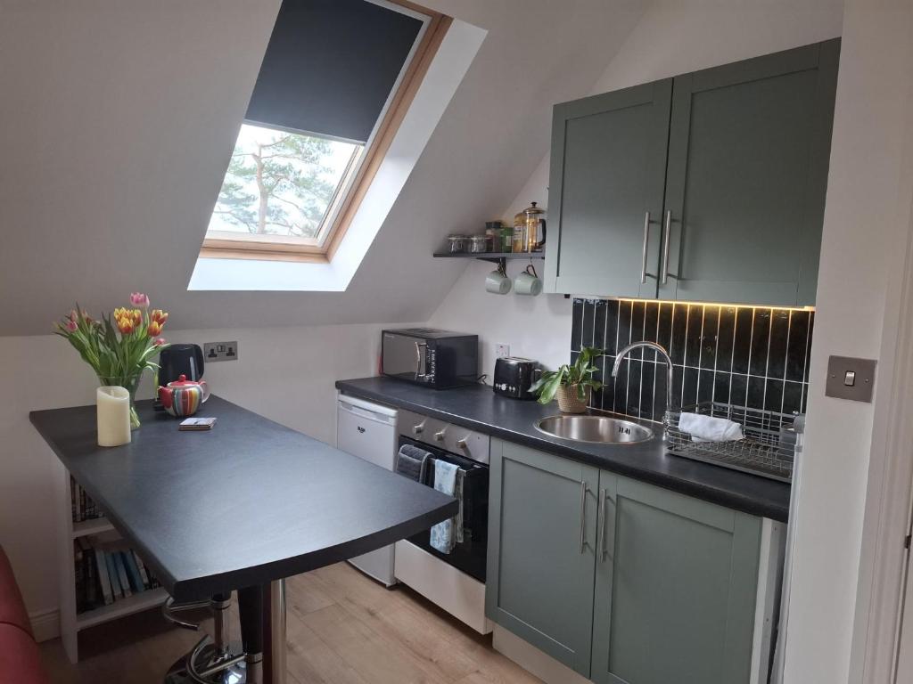 a kitchen with a black counter top and a sink at The Loft at 522 in Woodburn