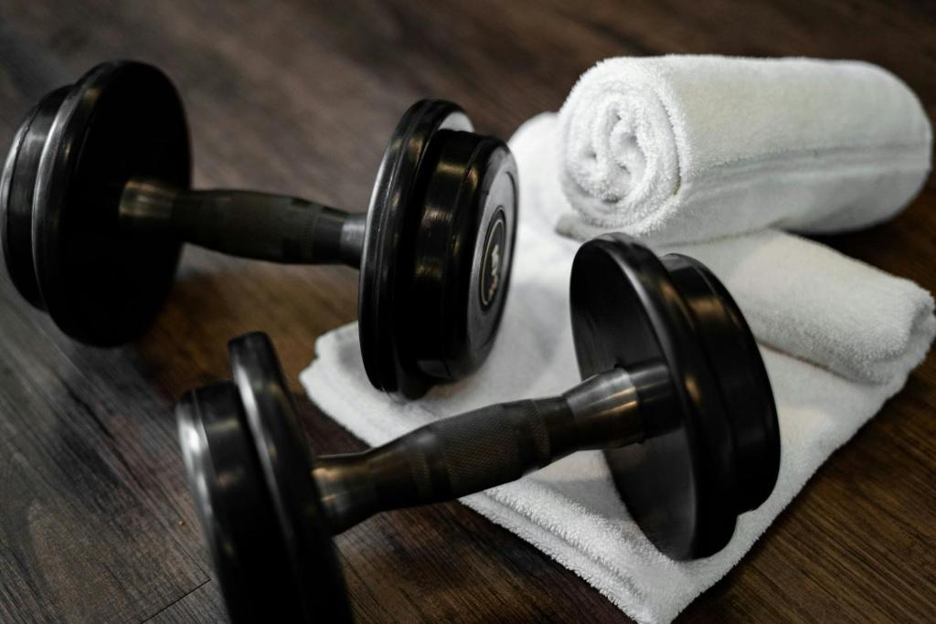 A close-up of black dumbbells placed on rolled white towels.