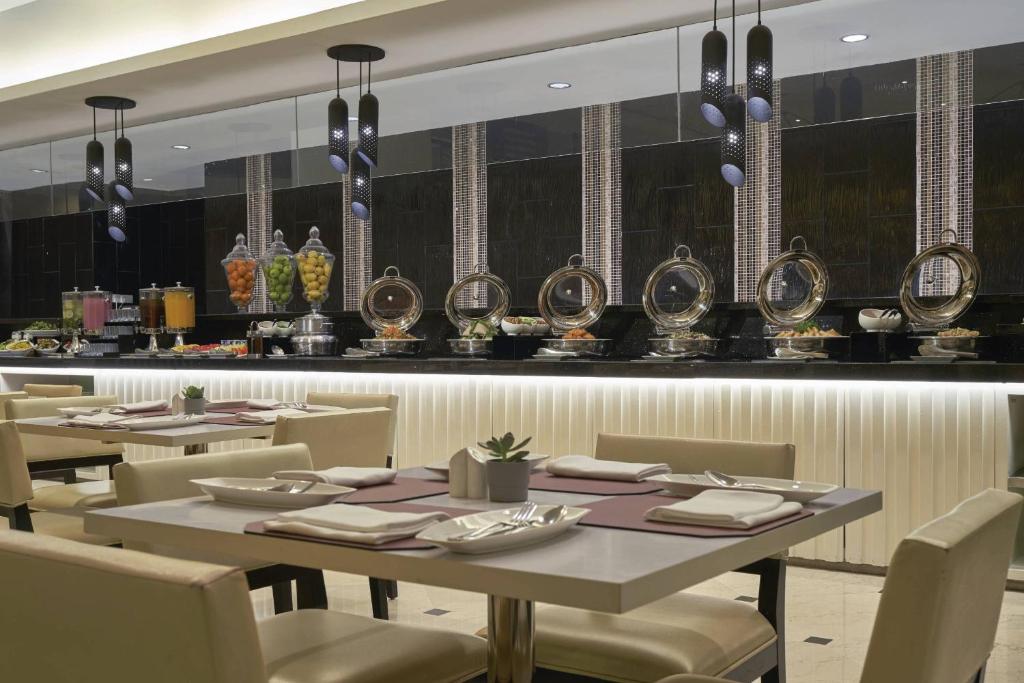 A polished dining room is set for a buffet meal beside mirrored service counters.