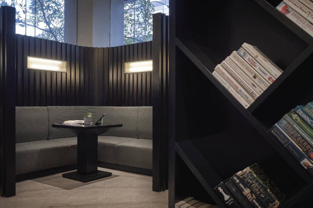 A tucked-away lobby seating nook pairs a corner banquette with a small table and bookcase.