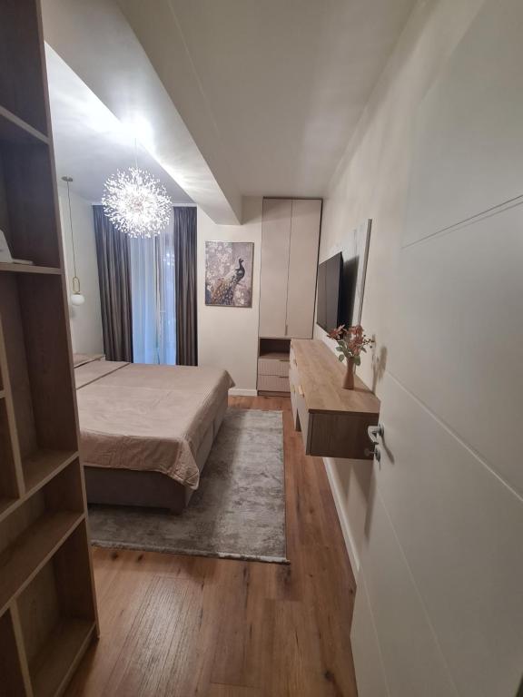 a bedroom with a bed and a chandelier at Sole Central Apartment in Râmnicu Vâlcea