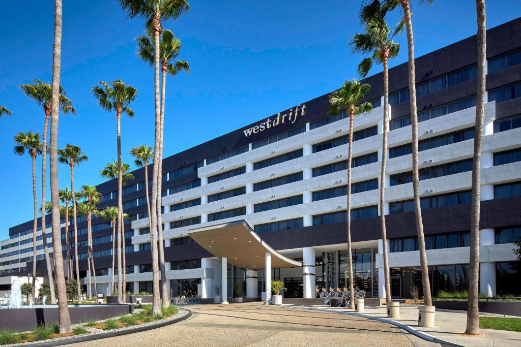 a hotel with palm trees in front of it at Westdrift Manhattan Beach, Autograph Collection in Manhattan Beach