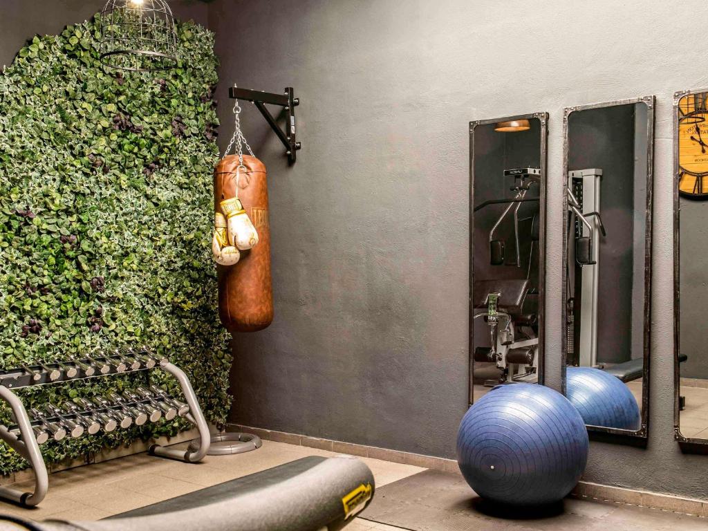 a gym with a green wall and a punching bag at Novotel Barcelona City in Barcelona