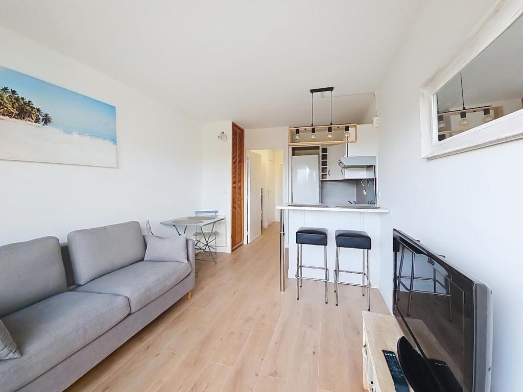 un salon avec un canapé et une cuisine dans l'établissement Vacation apartment near sea with private parking, à Antibes